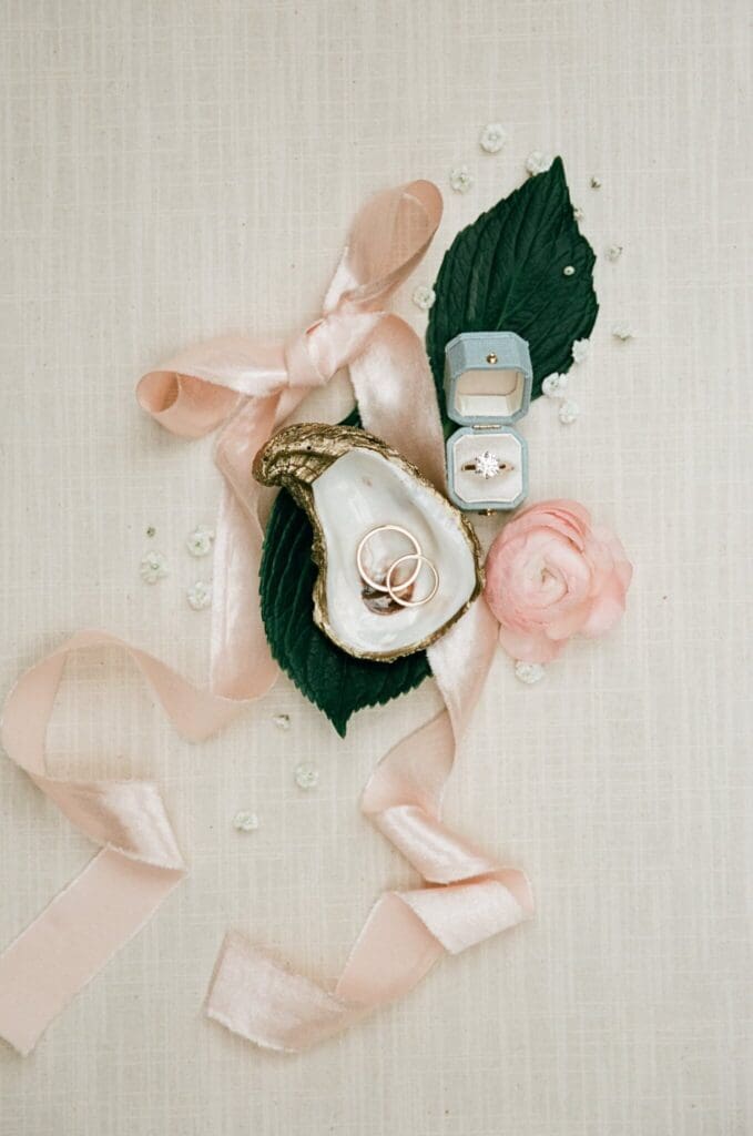 Flat lay of wedding bouquet, blush shoes, and custom invitation suite