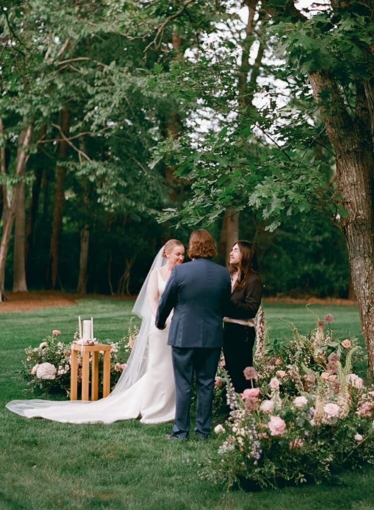 Officiant blessing the marriage at the altar during an intimate backyard wedding ceremony