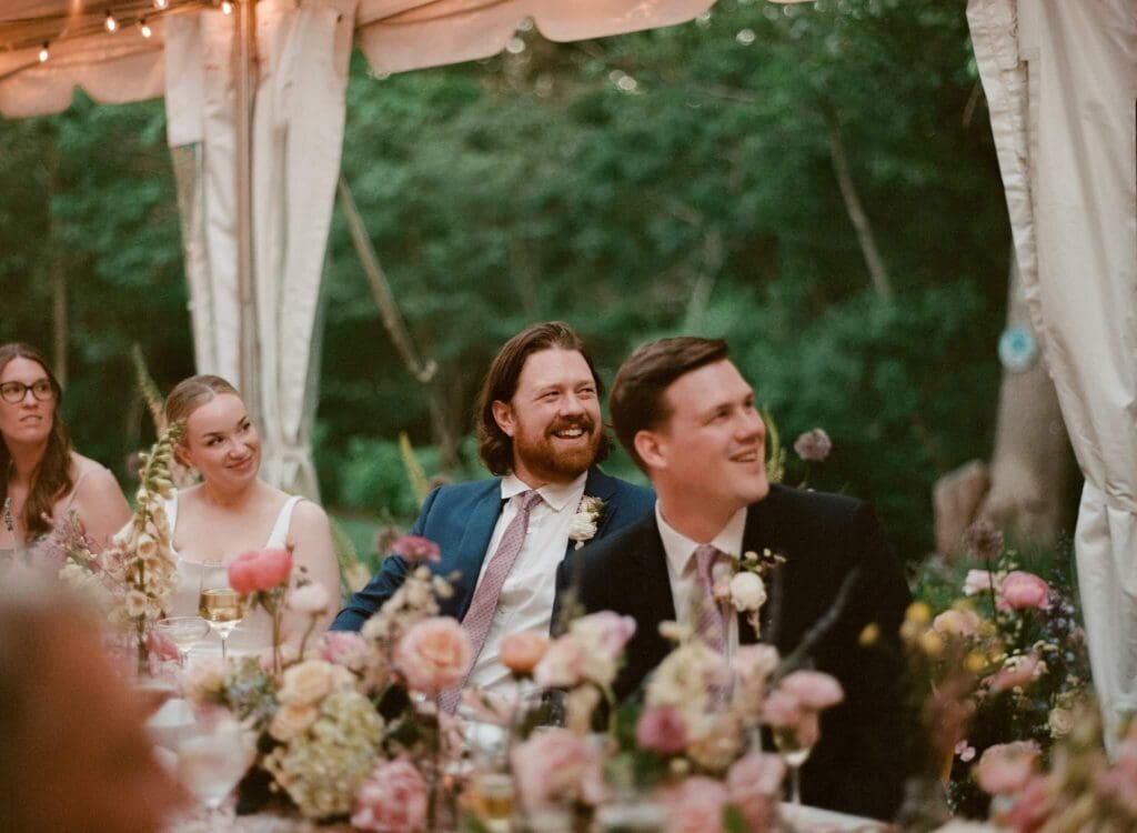 Guests enjoying dinner under string lights at a small backyard wedding on Cape Cod