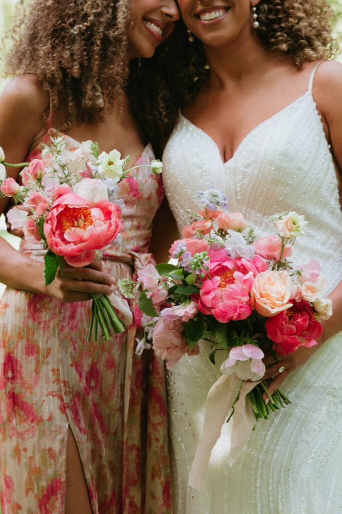Bride and bridesmaid holding bright, textural bouquets in a palette of cohesive wedding flowers