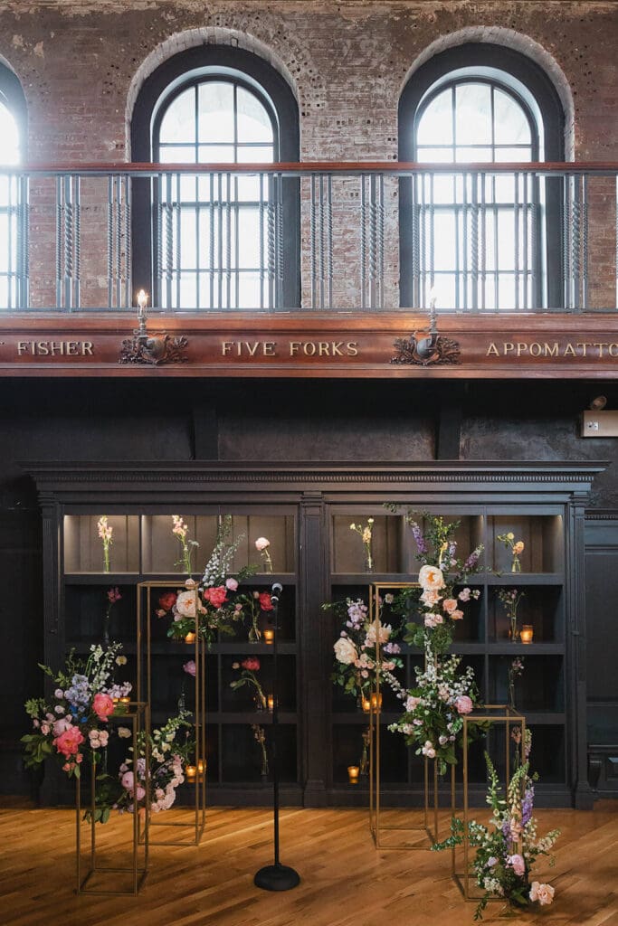 Cohesive wedding flowers in gold frames ceremony installation