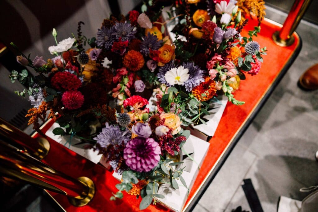 Flat lay of fall bouquet and boutonnière on a lacquered red tray