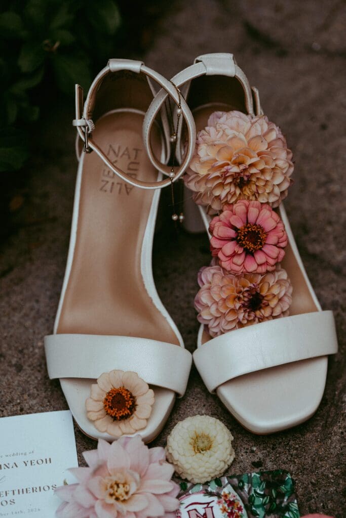 Flat lay of white bridal heels with a bouquet