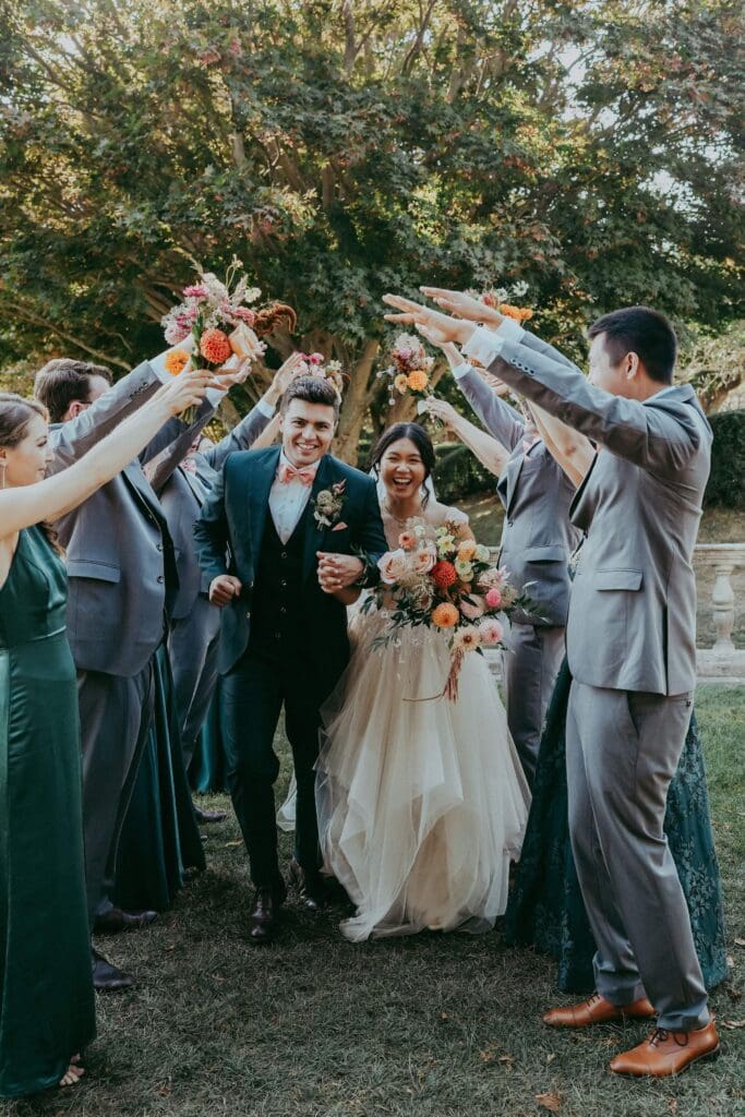 Bridal party raising bouquets filled with blooms that tied into repurposed floral installations throughout the day