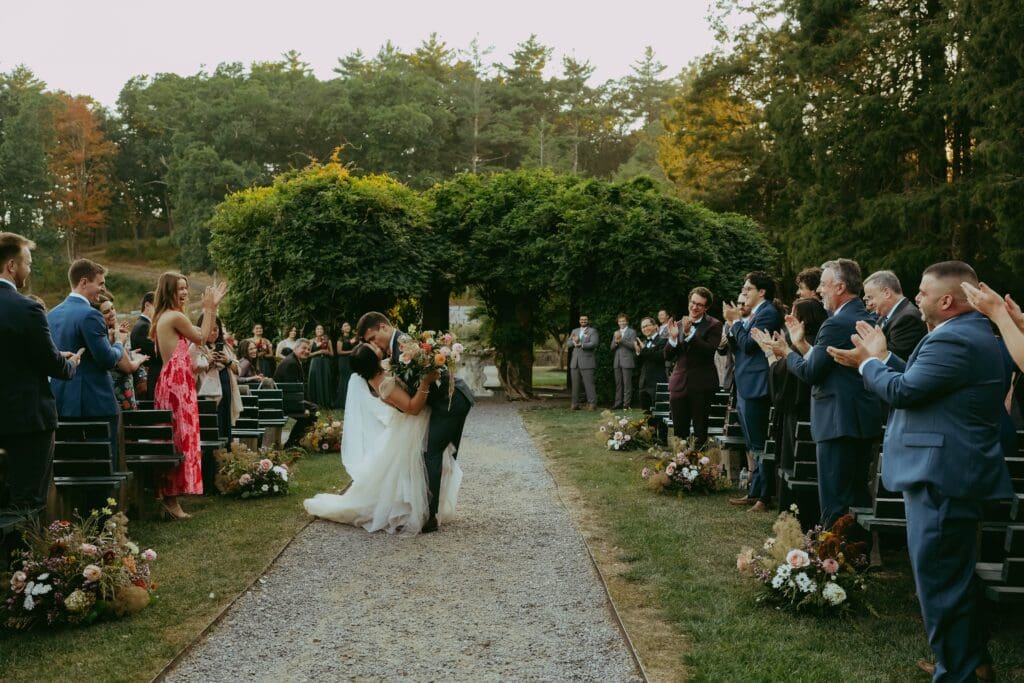 View down the aisle at an outdoor ceremony with grounded floral arrangements