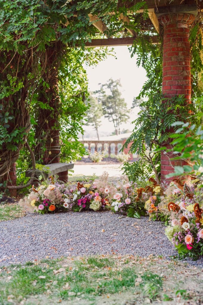 Ceremony florals repurposed into a dreamy installation under wooden arbor at Turner Hill wedding venuein Boston