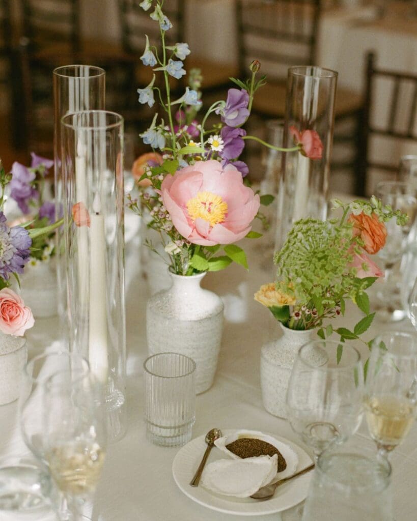 Seasonal spring centerpiece with pink peony, purple sweet peas, and greenery in minimalist ceramic bud vases, styled for a Beauport Hotel Gloucester wedding.