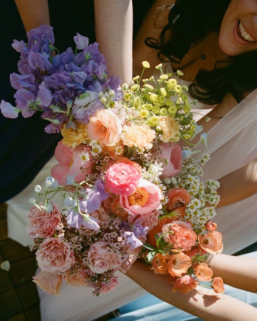 Close-up of a colorful wedding bouquet featuring May wedding flowers in coral, lavender, and golden yellow, perfect for a beach wedding in Gloucester.